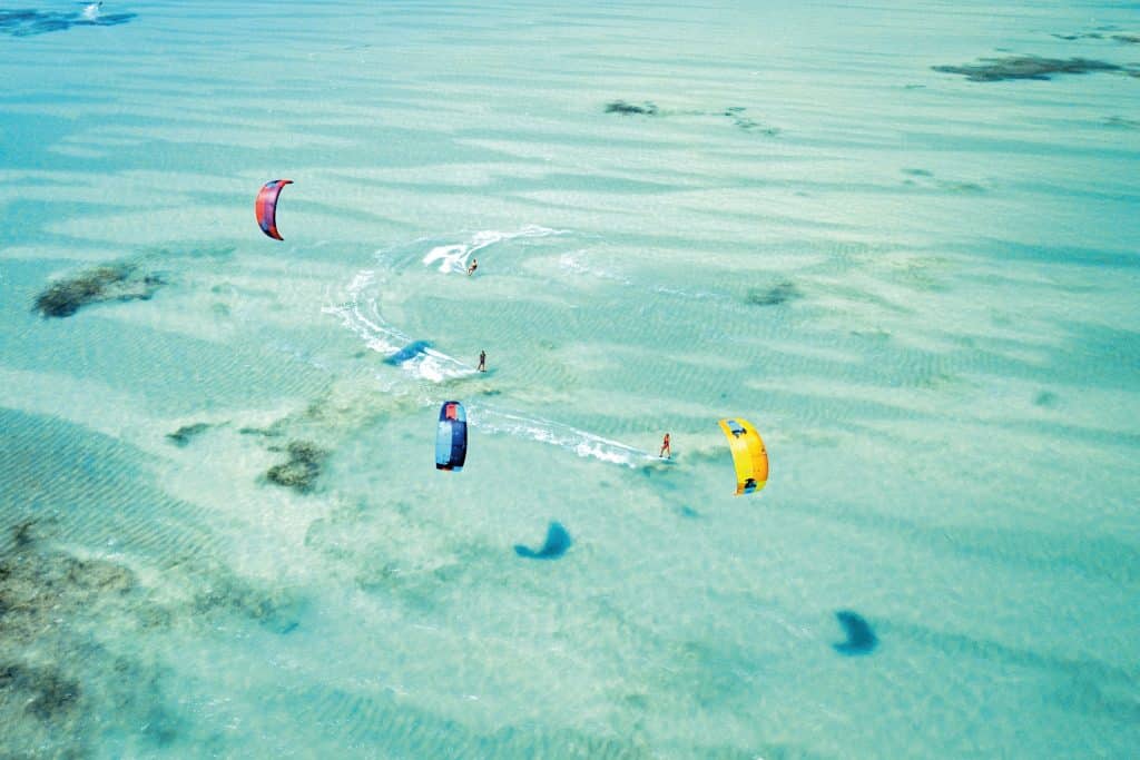 Kitesurfers op turquoise water bij de kust van Zanzibar, Tanzania