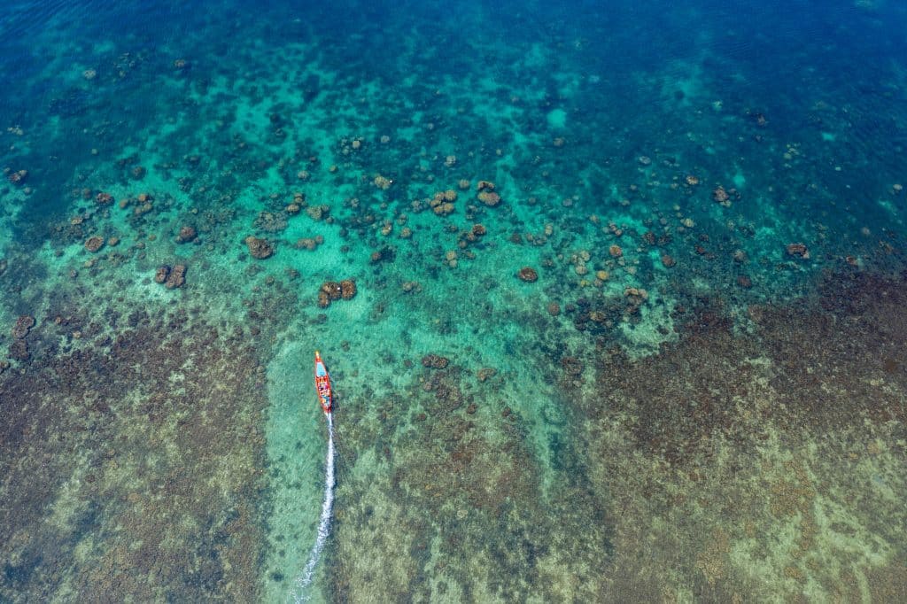 Boot op helderblauwe zee bij koraalrif in Indonesië