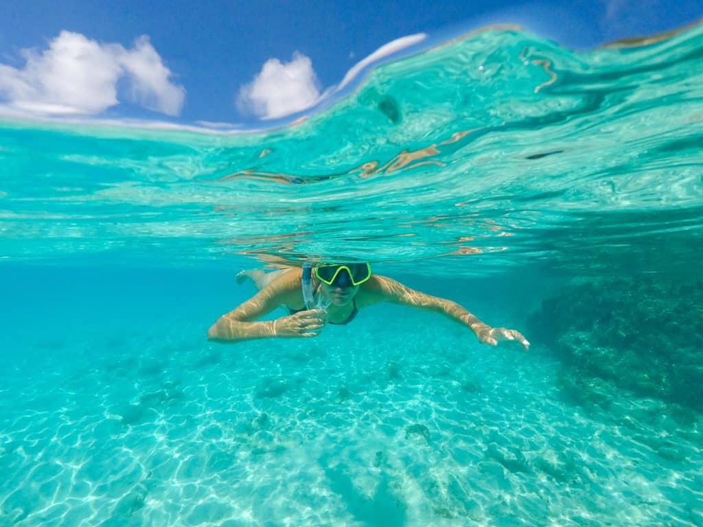 Snorkelaar in helderblauw water bij de Bahama's