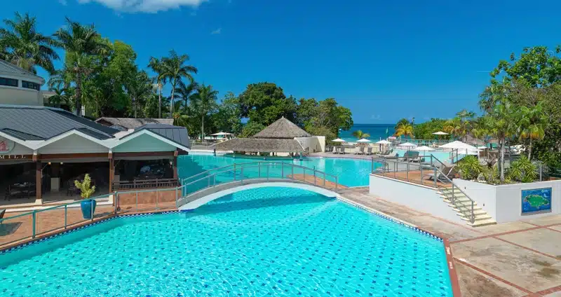 Groot zwembad met brug en uitzicht op zee in Jamaica