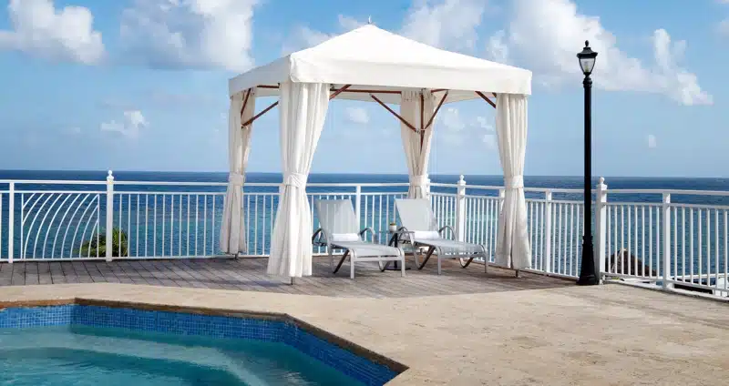 Cabana met ligstoelen bij zwembad in Jamaica