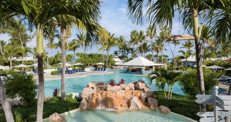 Zwembad met waterval en palmbomen in Turks en Caicos