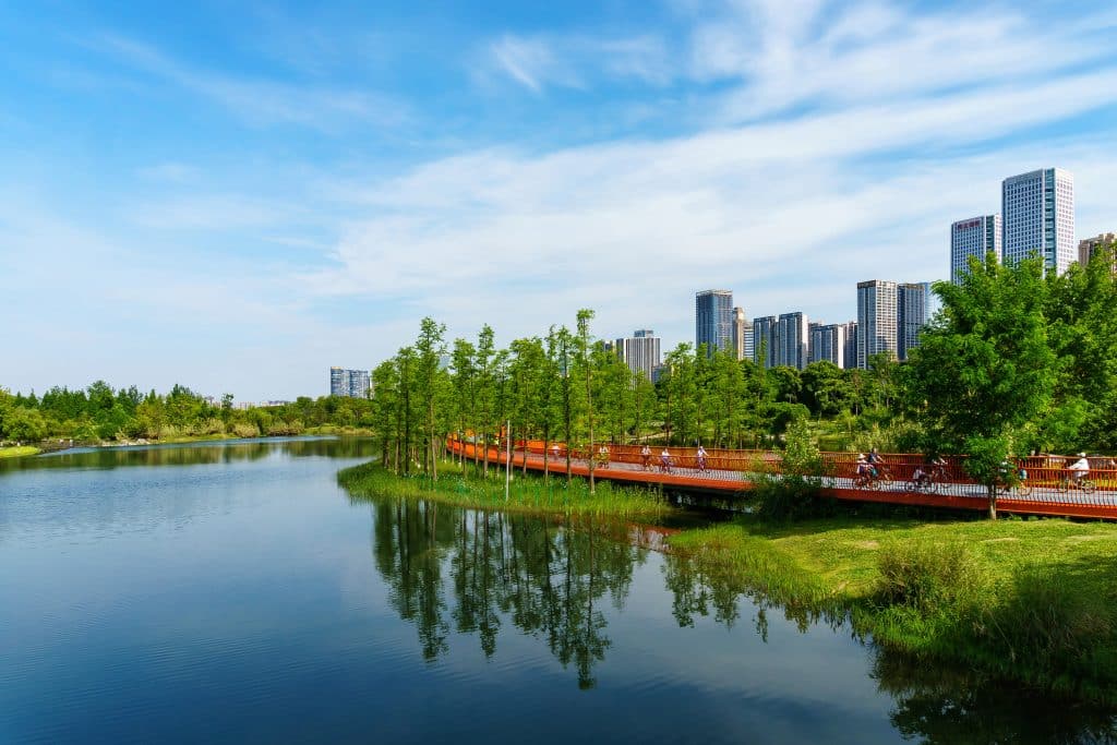 Fietsers op pad langs meer met skyline in China