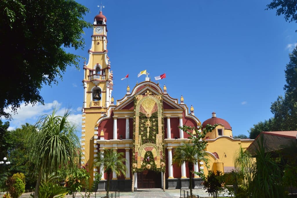 Gele en rode kerk met toren in Mexico