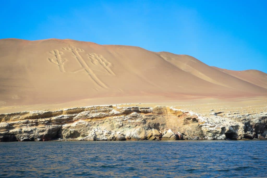 Zandheuvel met geoglief aan kust in Peru