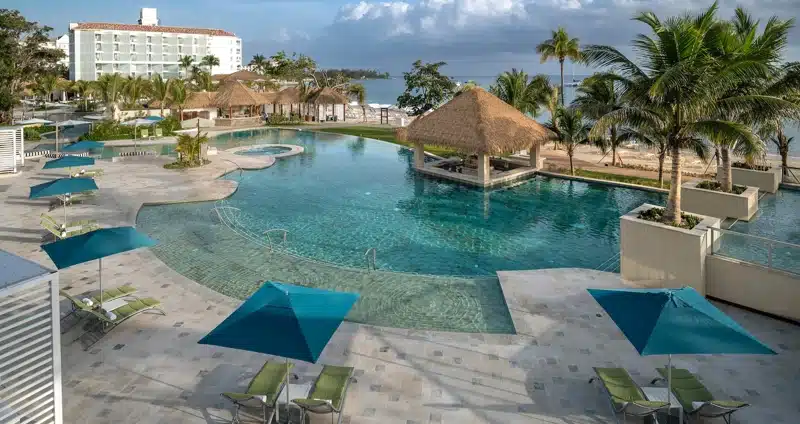 Zwembad met bar en palmbomen bij Sandals Dunn’s River