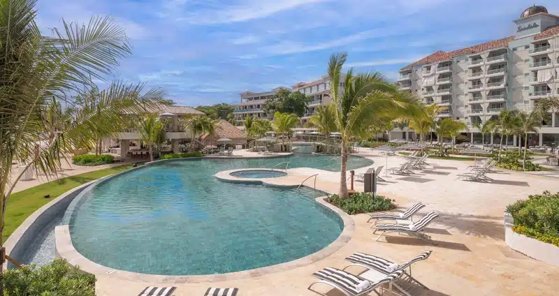 Zwembad met ligbedden en palmbomen bij Sandals Dunn’s River