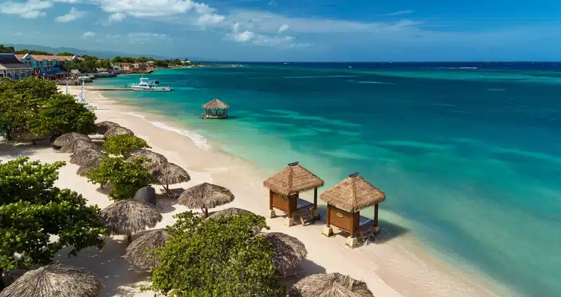 Strand bij Sandals Montego Bay met palmbomen en cabana’s