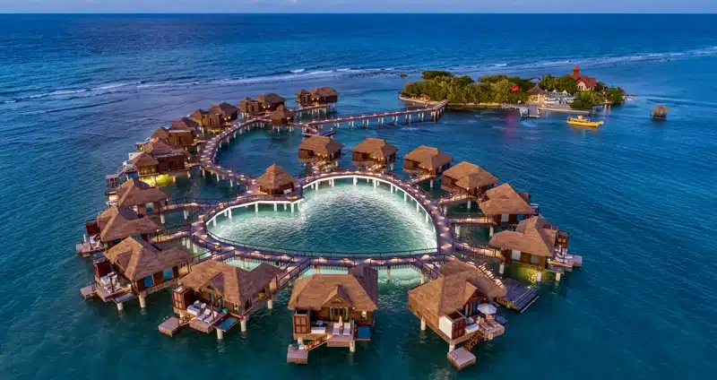 Overwater villa’s bij avond bij Sandals Royal Caribbean