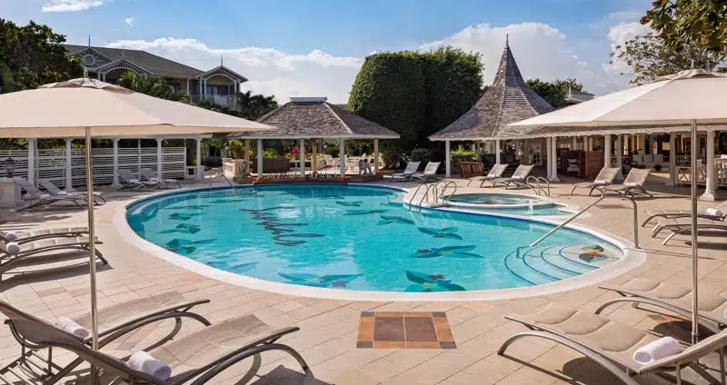 Zwembad met ligstoelen bij resort in Jamaica