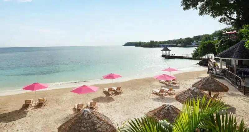 Strand met roze parasols bij Sandals Royal Plantation