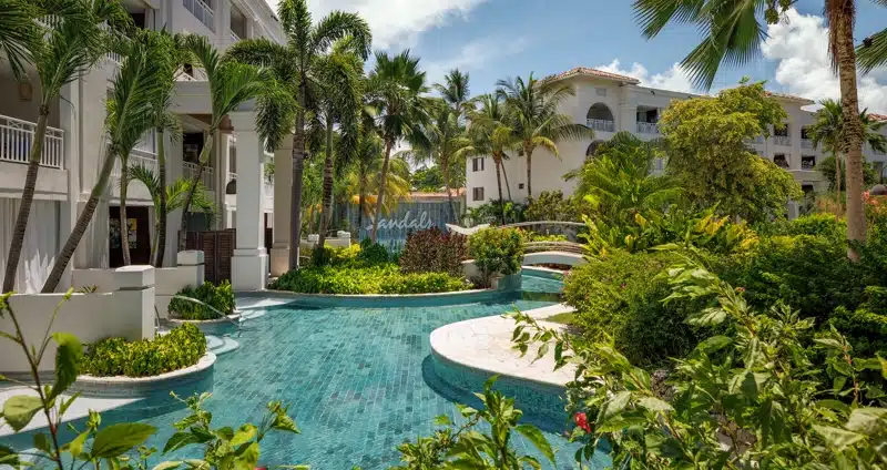 Zwembad tussen tuinen en gebouwen bij Sandals Barbados