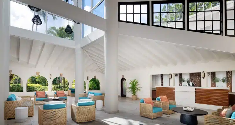 Lichte lobby met zitjes en receptie bij Sandals Grande Antigua