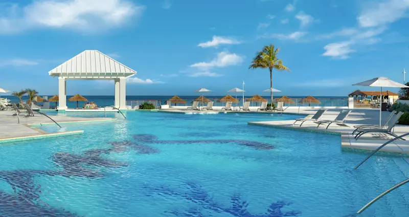 Groot zwembad met ligbedden bij Sandals Royal Bahamian