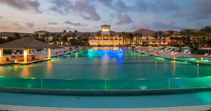 Groot zwembad met verlichting bij schemering, Curaçao