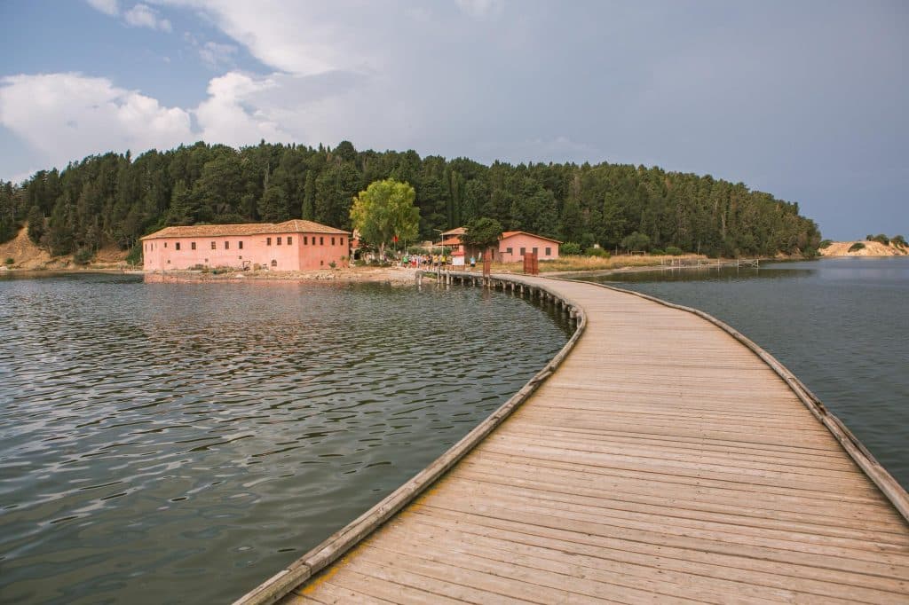Houten brug naar eiland met klooster in Albanië