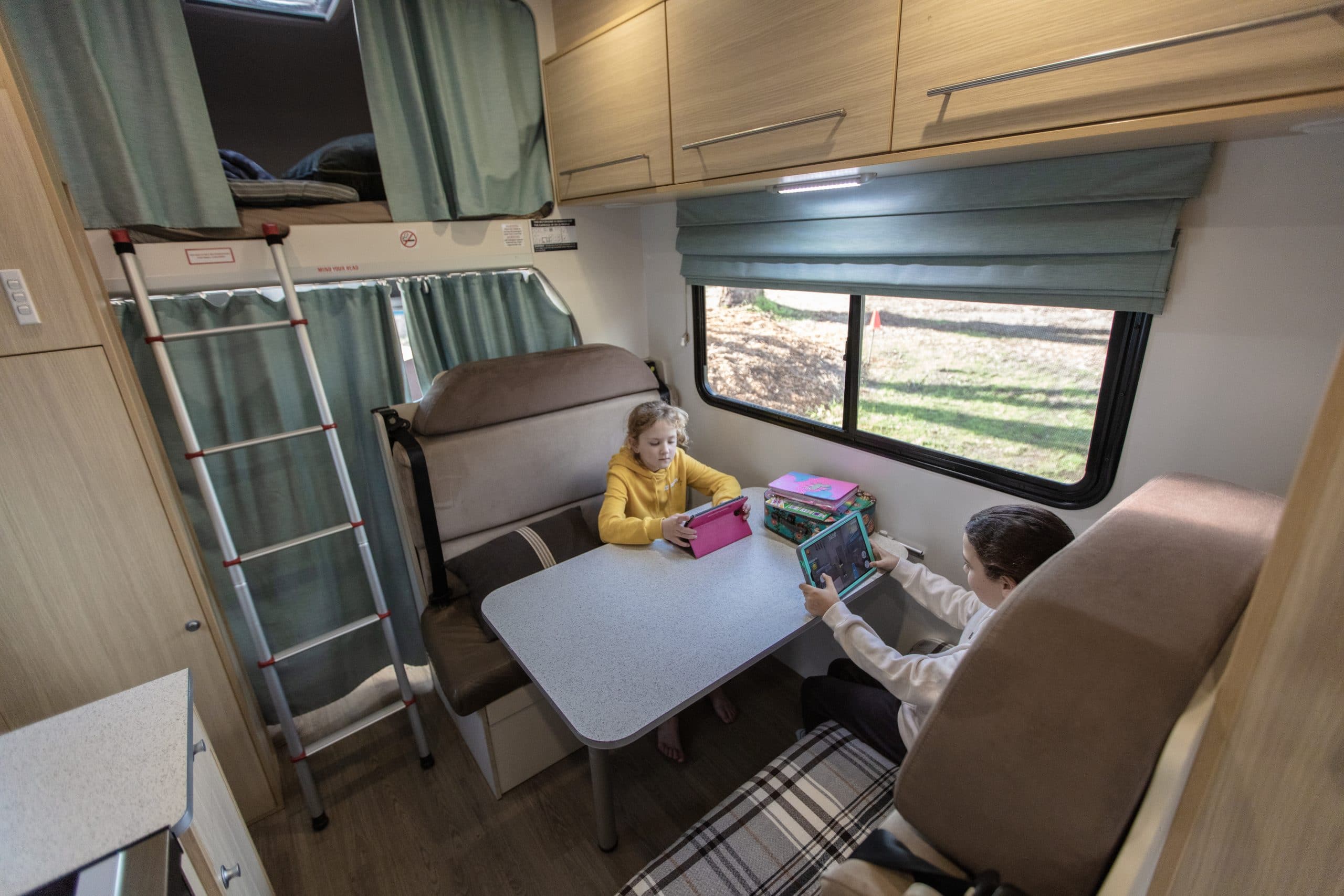 Kinderen met tablets in camper Nieuw Zeeland