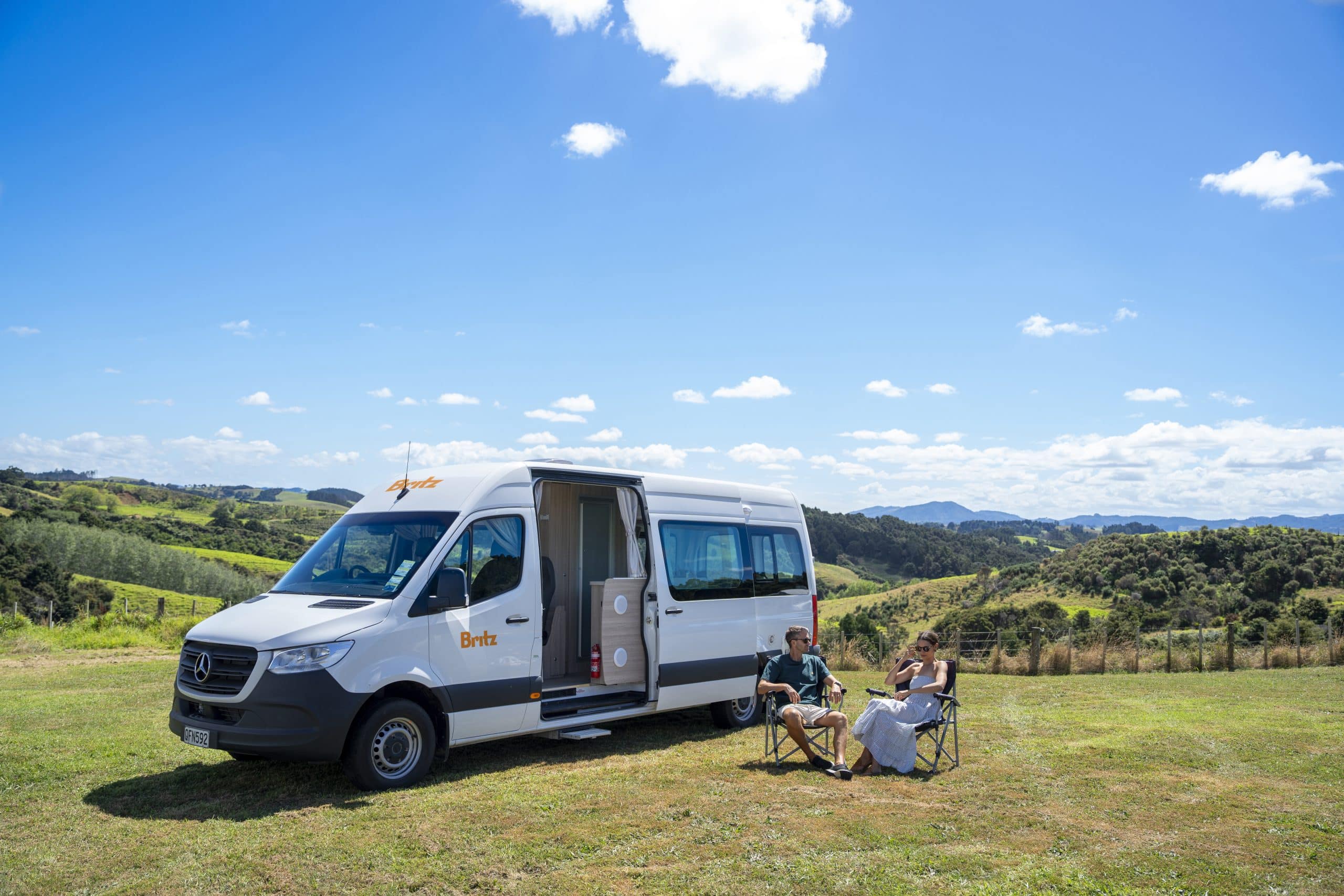 Camper met open deur in heuvels Nieuw-Zeeland