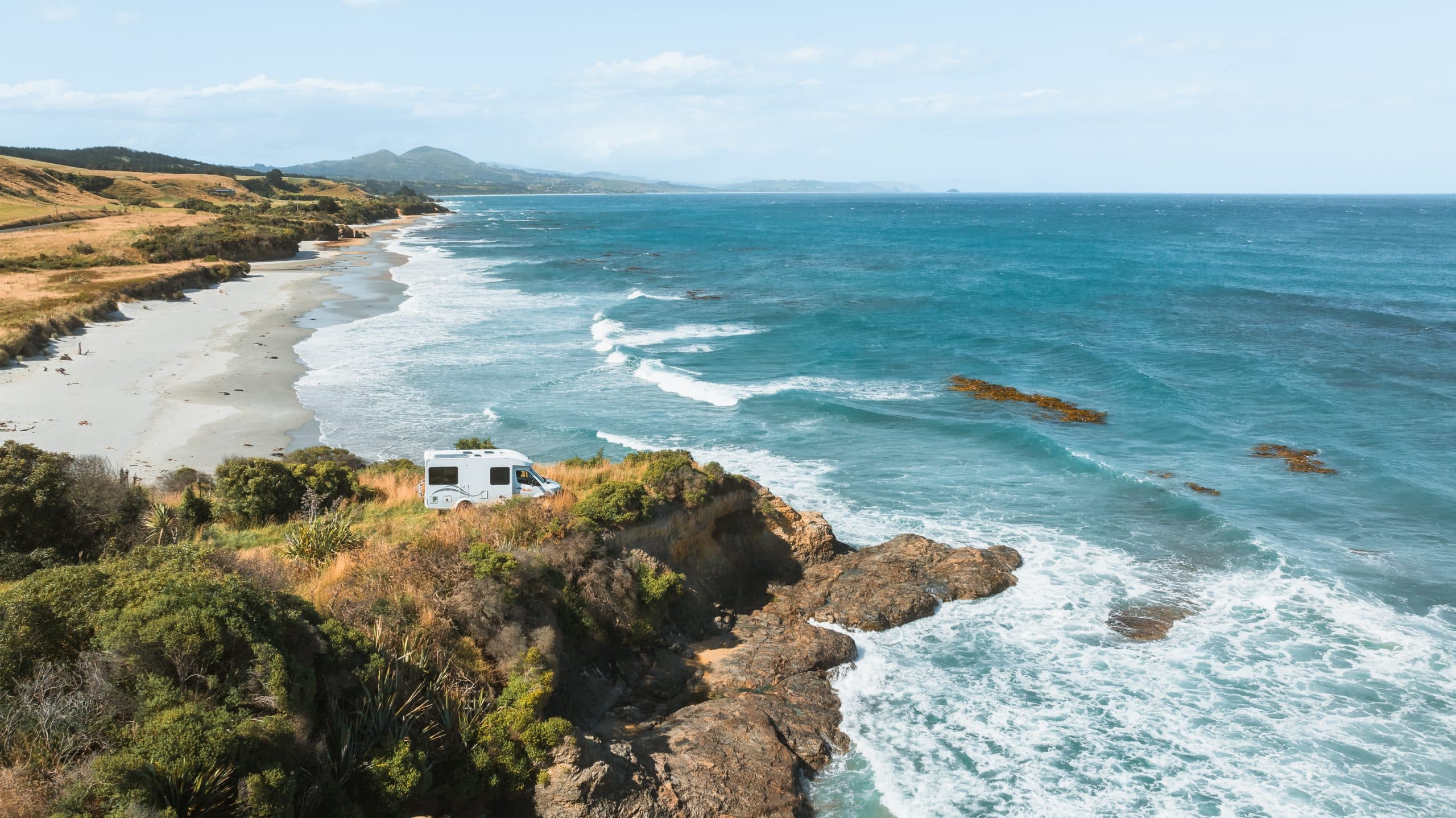 Camper bovenop klif aan zee in Nieuw-Zeeland