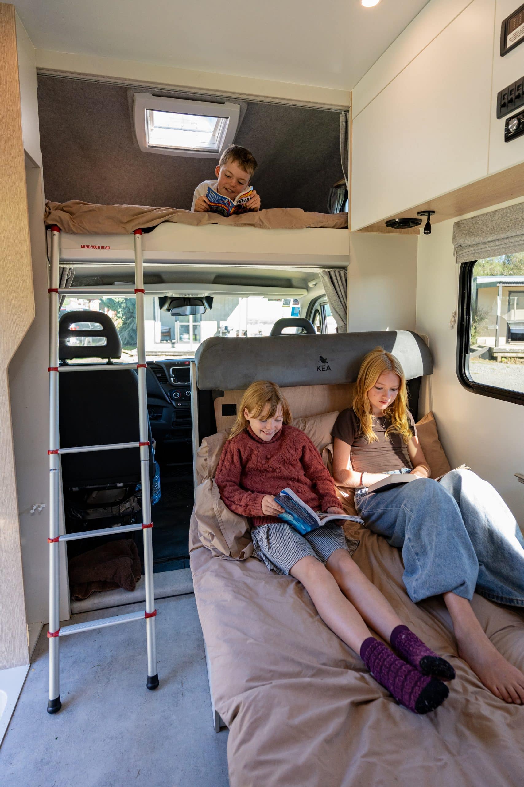 Kinderen lezen en rusten in camper Nieuw-Zeeland