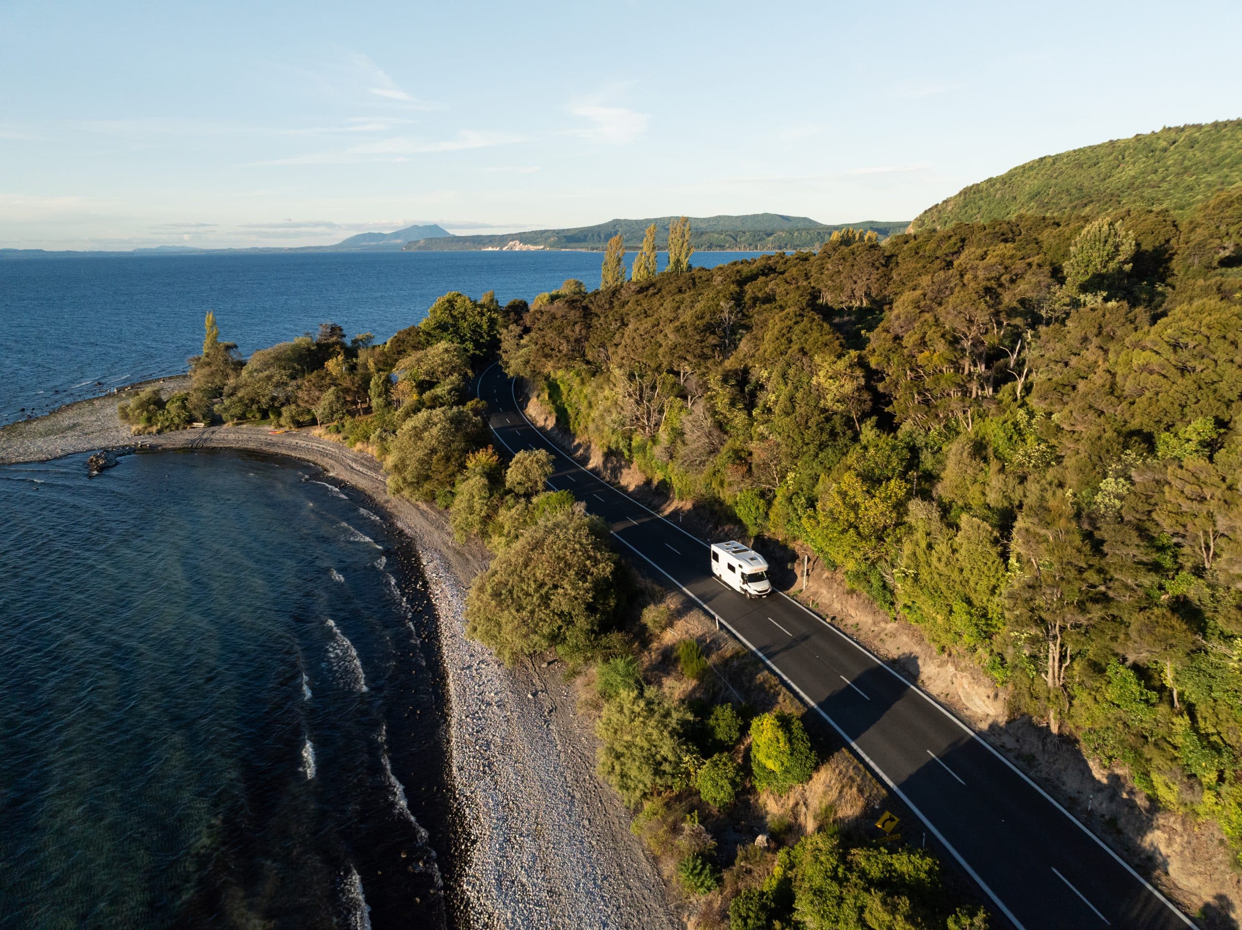 Camper rijdt langs kustlijn op Noordereiland Nieuw-Zeeland