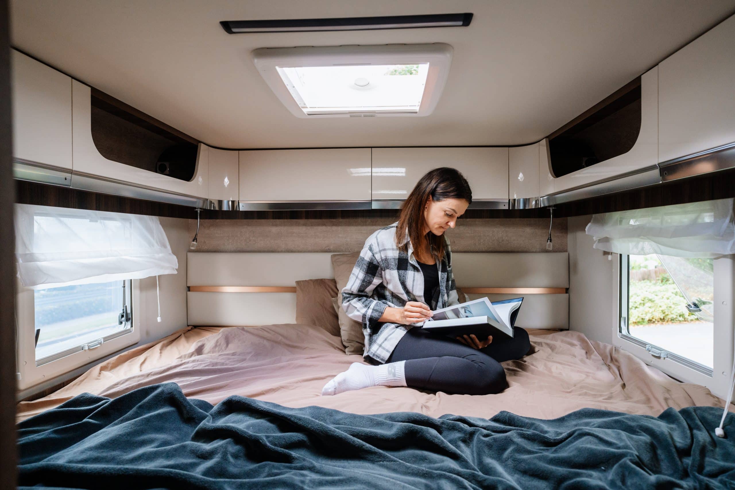Vrouw leest op bed in camper Nieuw-Zeeland