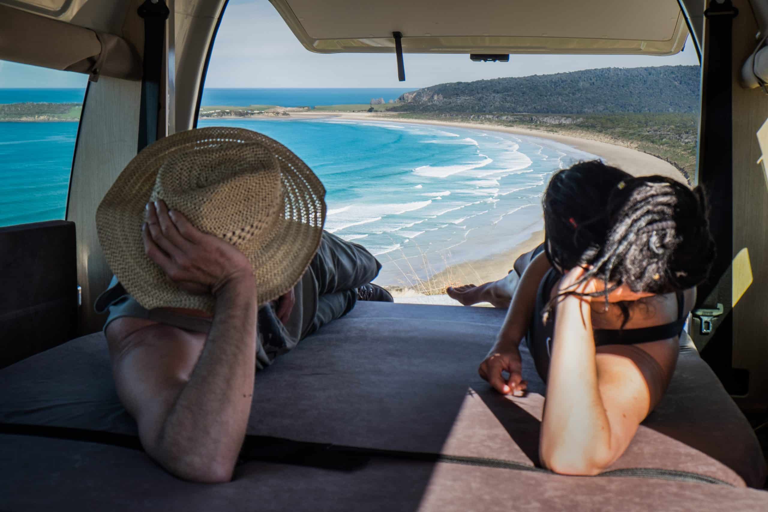 Koppel ligt in Hitop camper Cheapa Campa met zeezicht, Nieuw-Zeeland