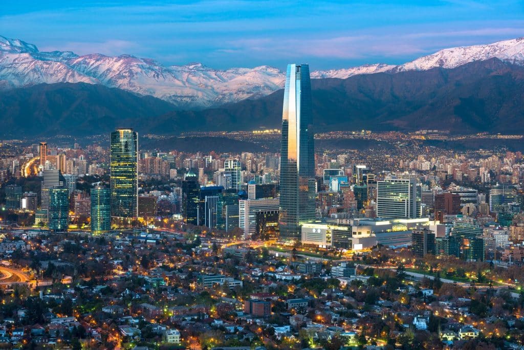 Avondzicht op Santiago met verlichte skyline en Andes
