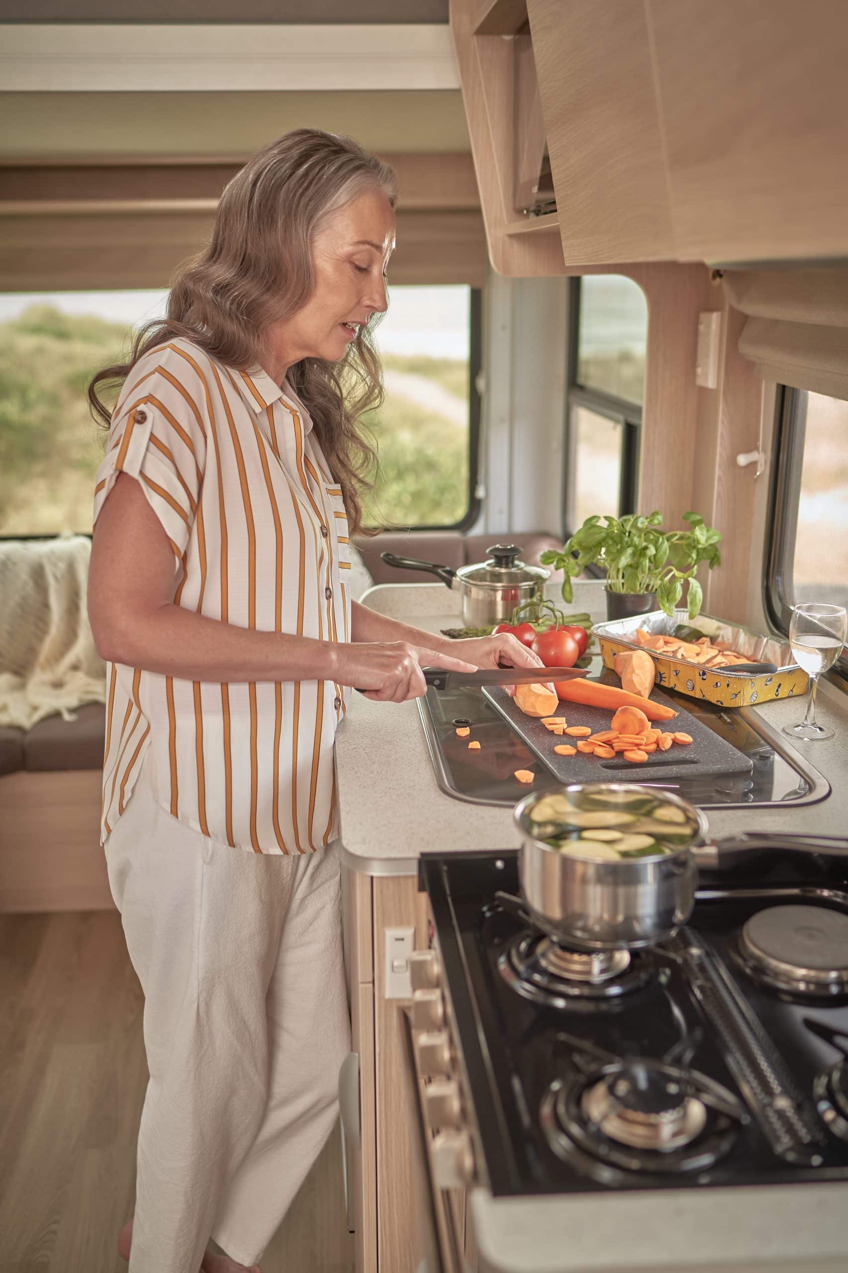 Vrouw kookt in camperkeuken in Nieuw-Zeeland