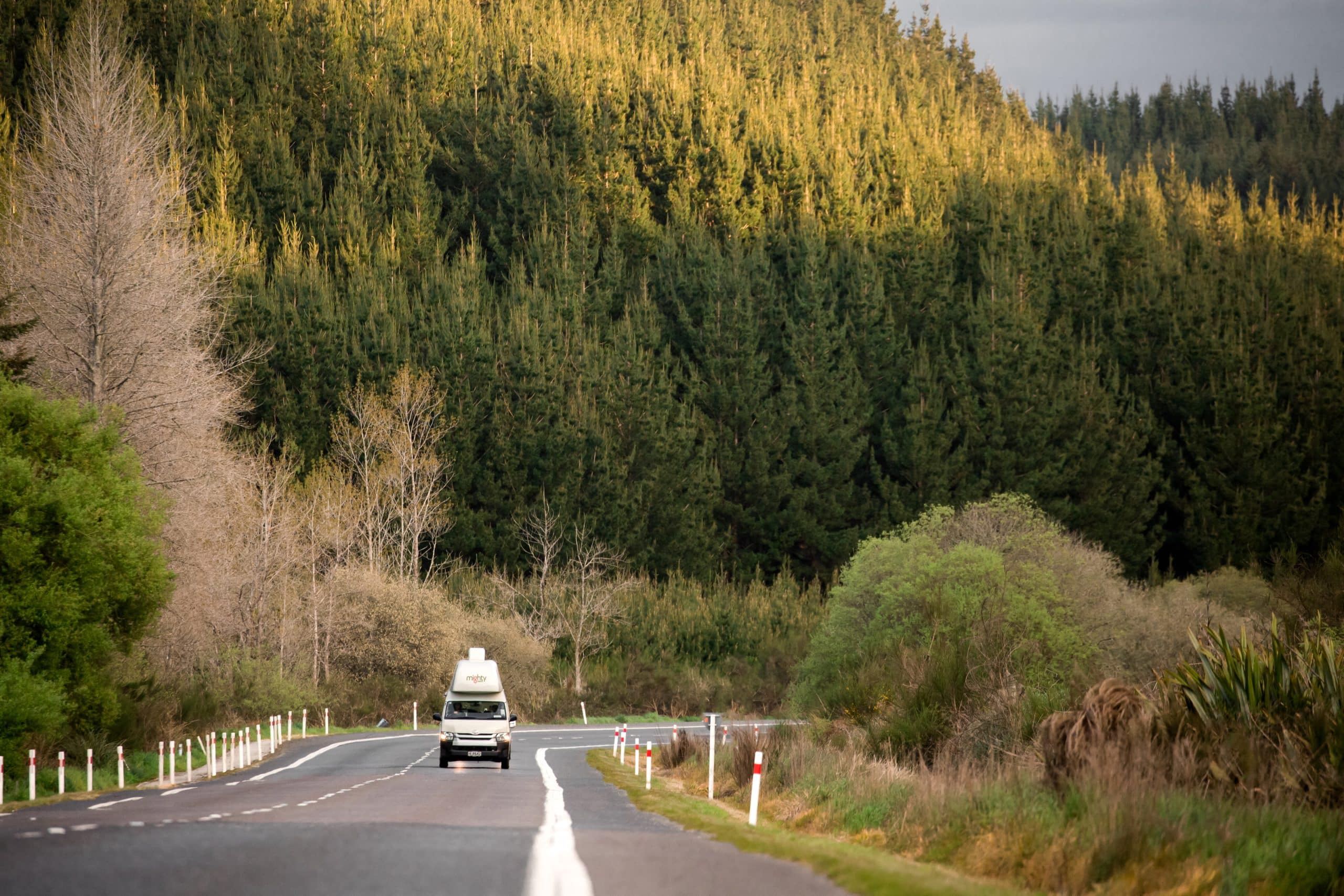 Mighty camper op weg door groen landschap Nieuw-Zeeland