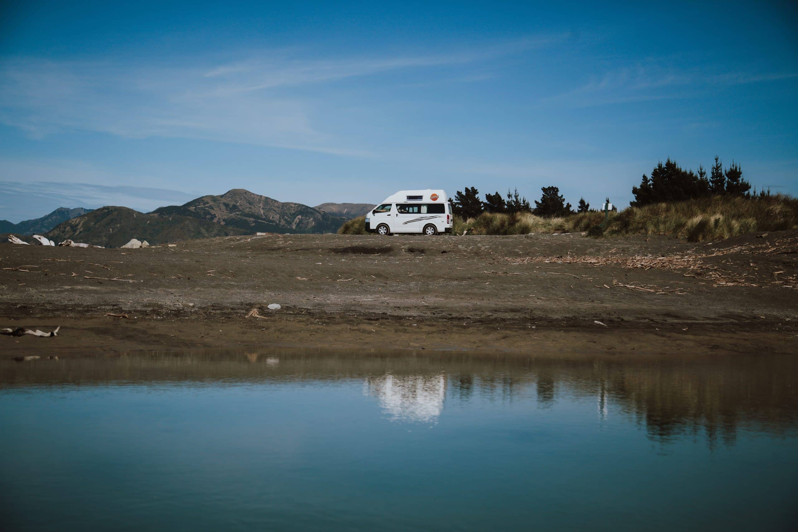 Camper bij water met bergen op achtergrond, Nieuw-Zeeland