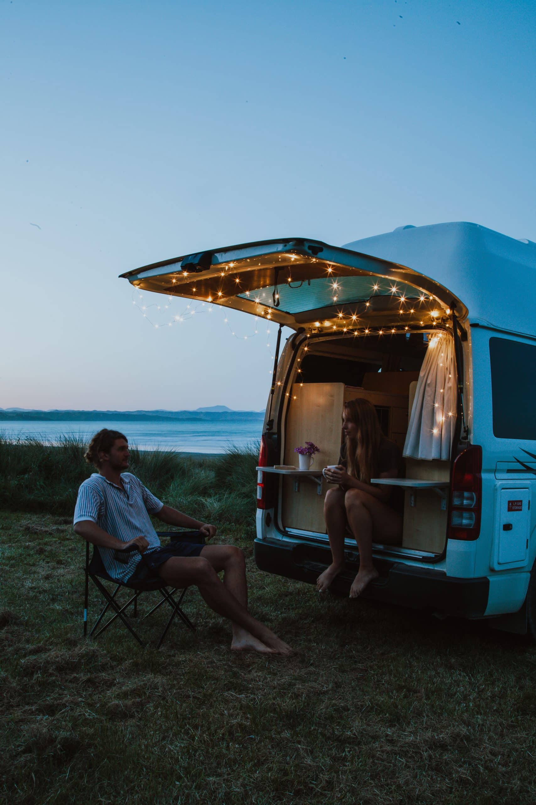 Twee personen bij open camperdeur met lichtjes, Nieuw-Zeeland