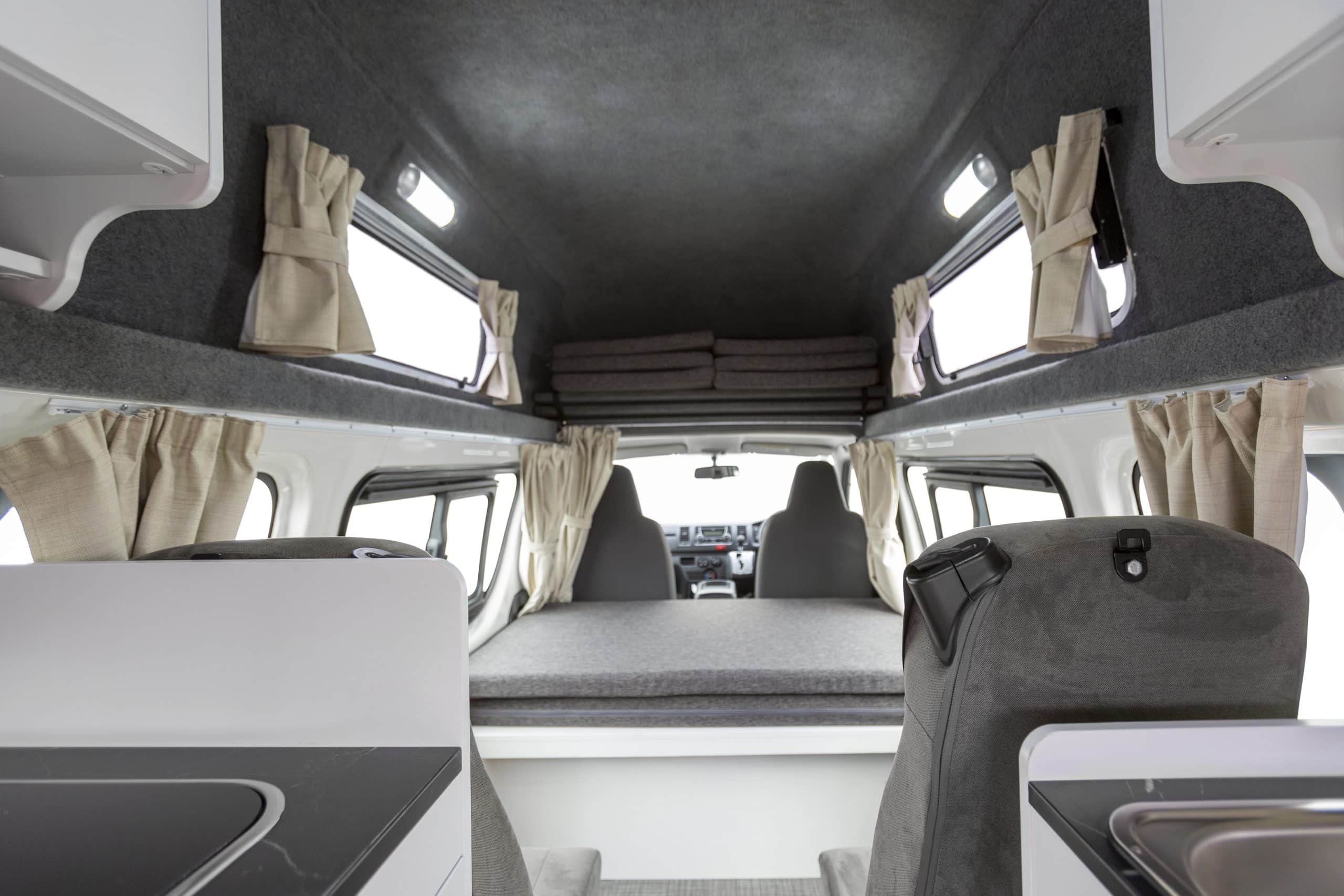 Zicht op zitgedeelte en bed in camper, Nieuw-Zeeland