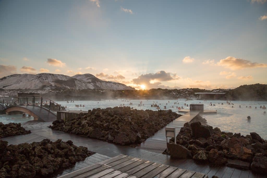 Mensen baden bij zonsondergang in Blue Lagoon, IJsland