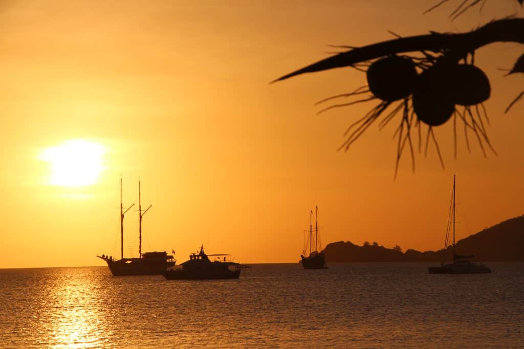 Boten voor anker bij zonsondergang in Indonesië