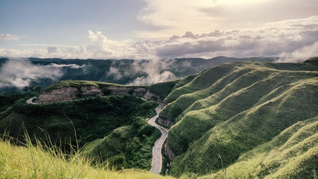 Kronkelende weg door groene heuvels op Sumba
