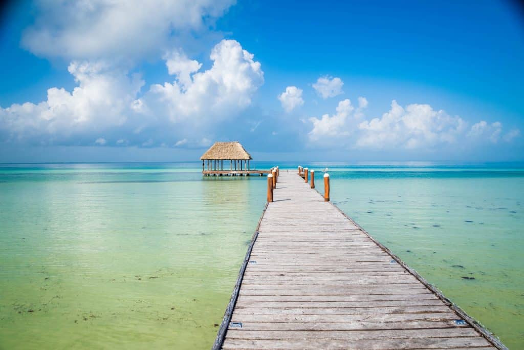 Houten steiger naar rieten hut in Mexico