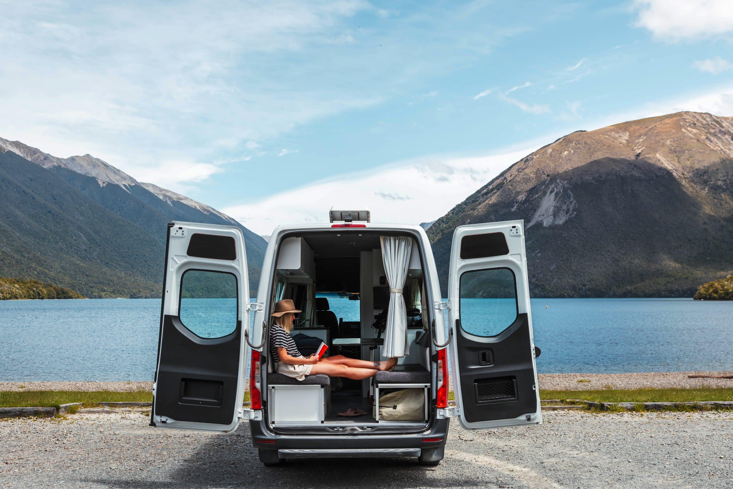 Vrouw in Deuce camper bij open achterdeuren Nieuw-Zeeland