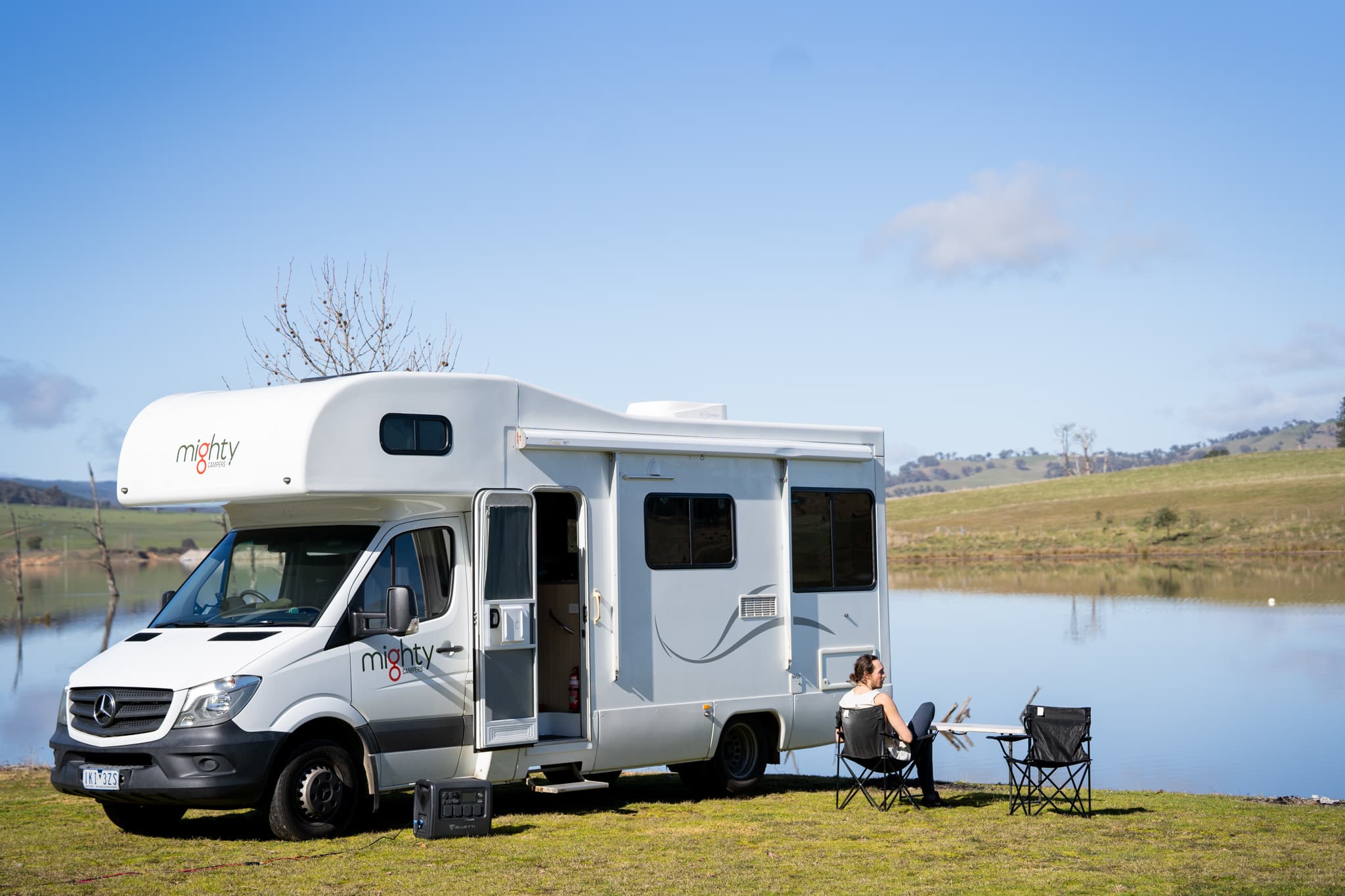 Man voor camper aan meer in Nieuw-Zeeland