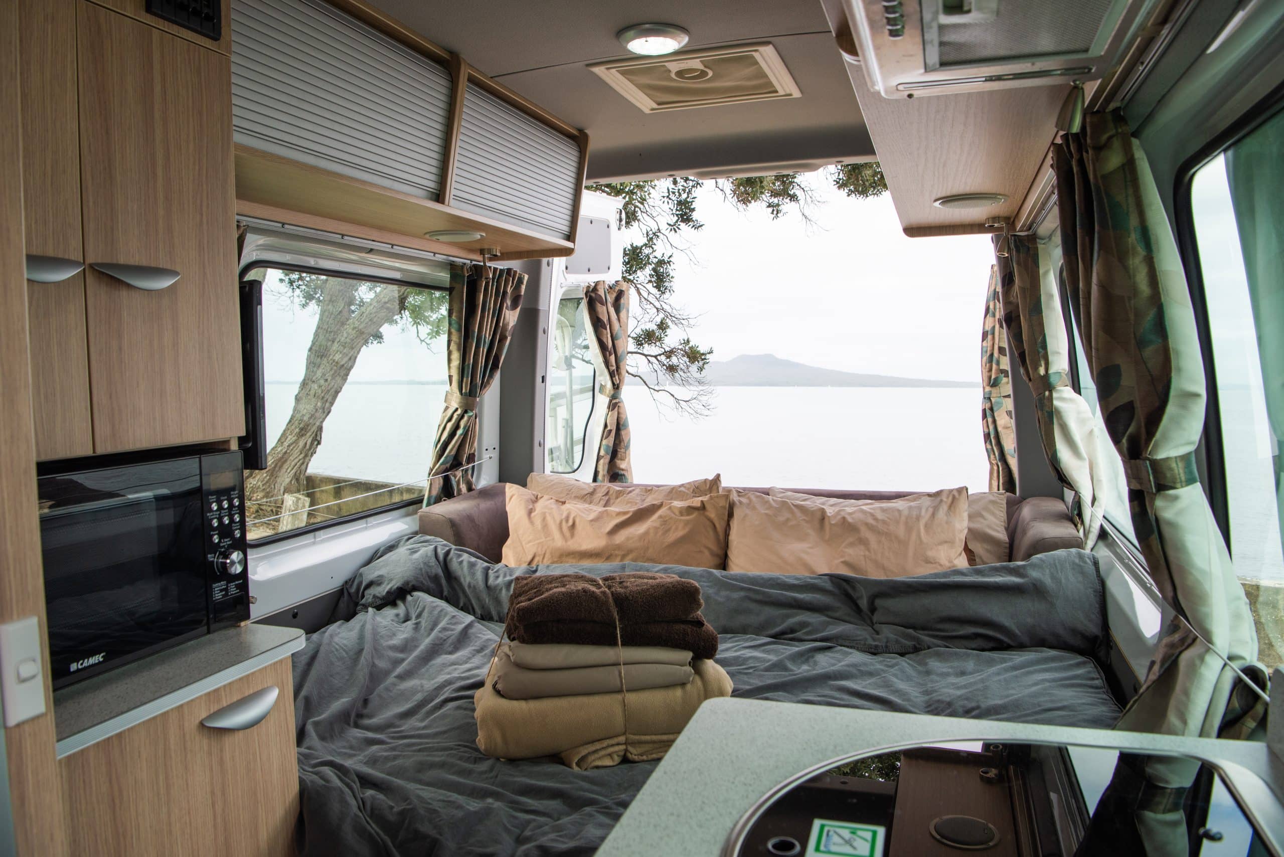 Bed in camper aan zee in Nieuw-Zeeland