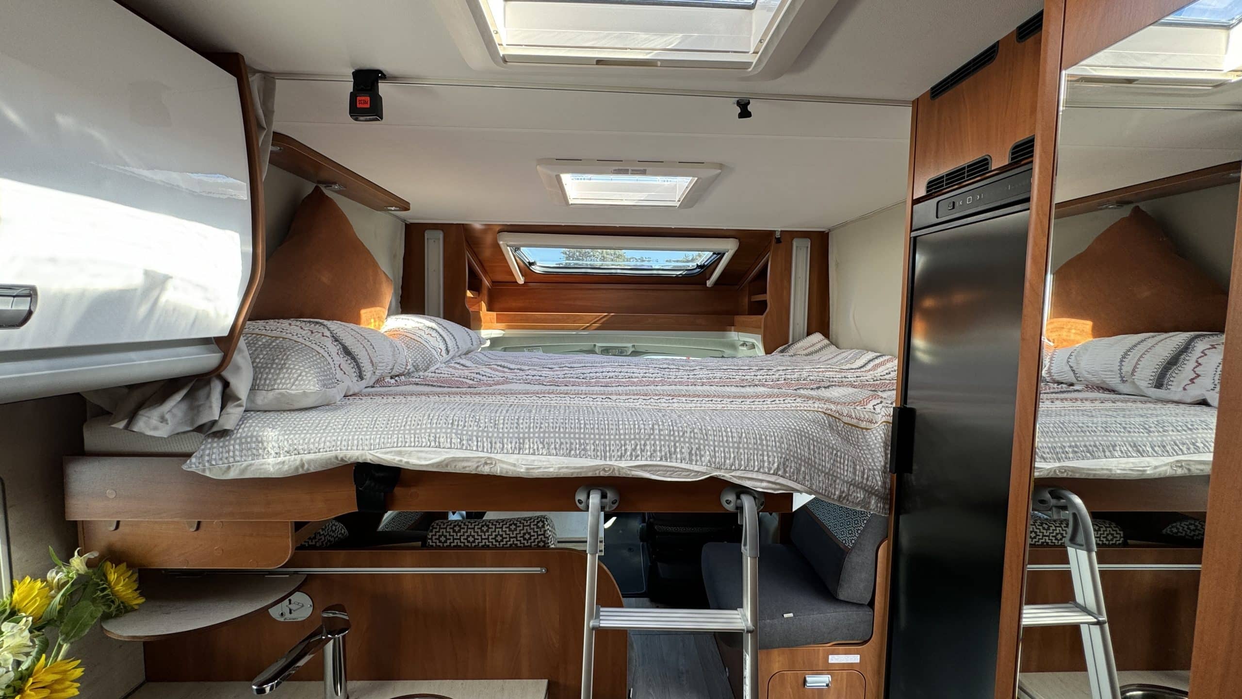 Opgeklapt bed boven zithoek in camper, Nieuw-Zeeland