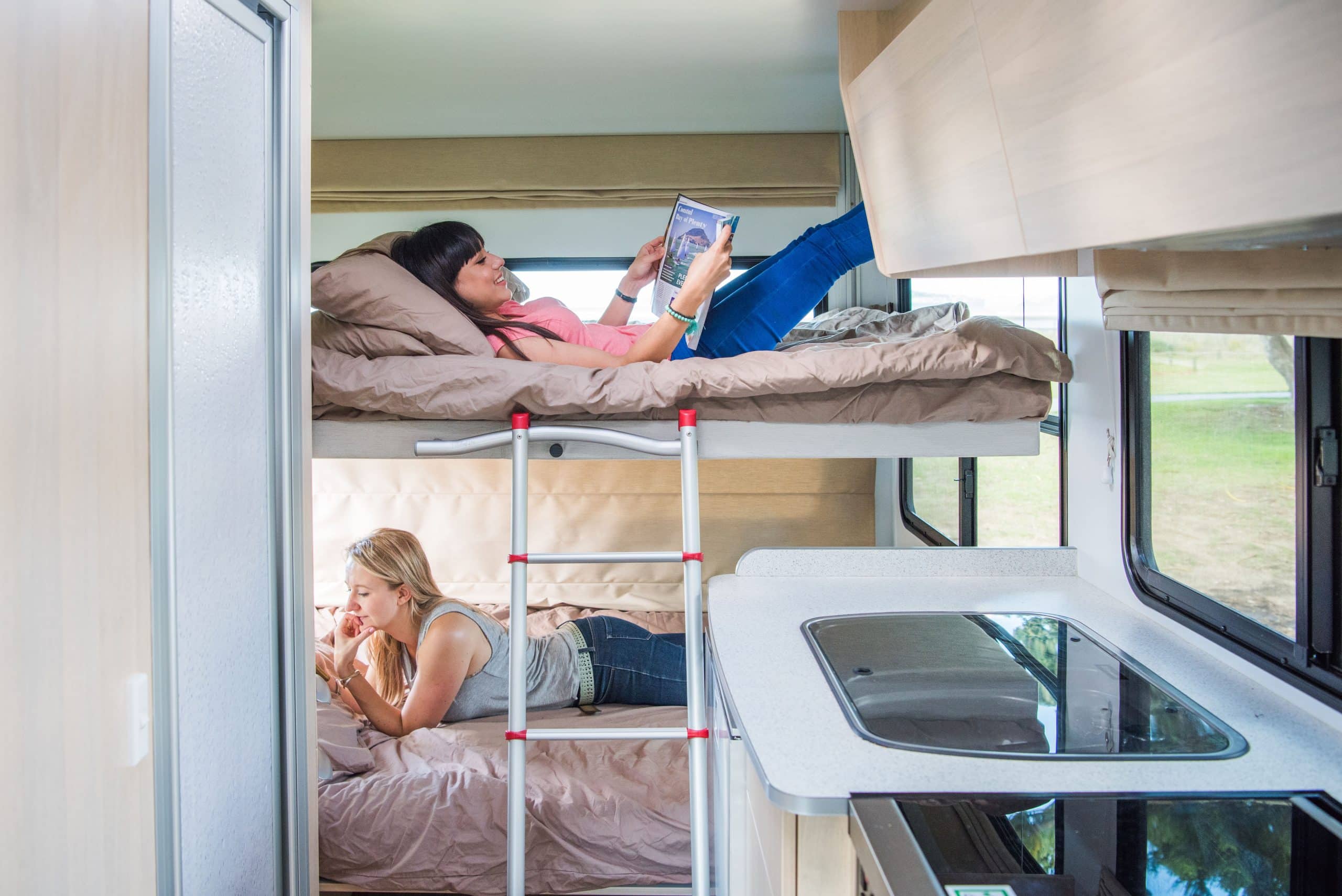 Twee vrouwen lezen in stapelbed camper Nieuw-Zeeland