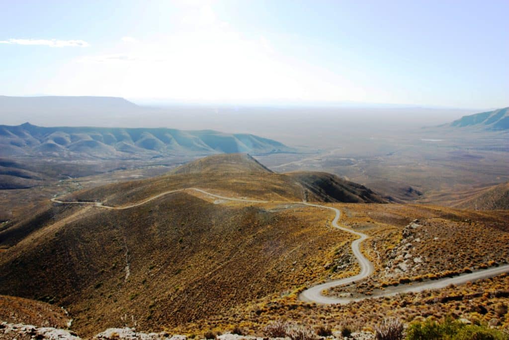 Bochtige weg door droog heuvellandschap in de Karoo