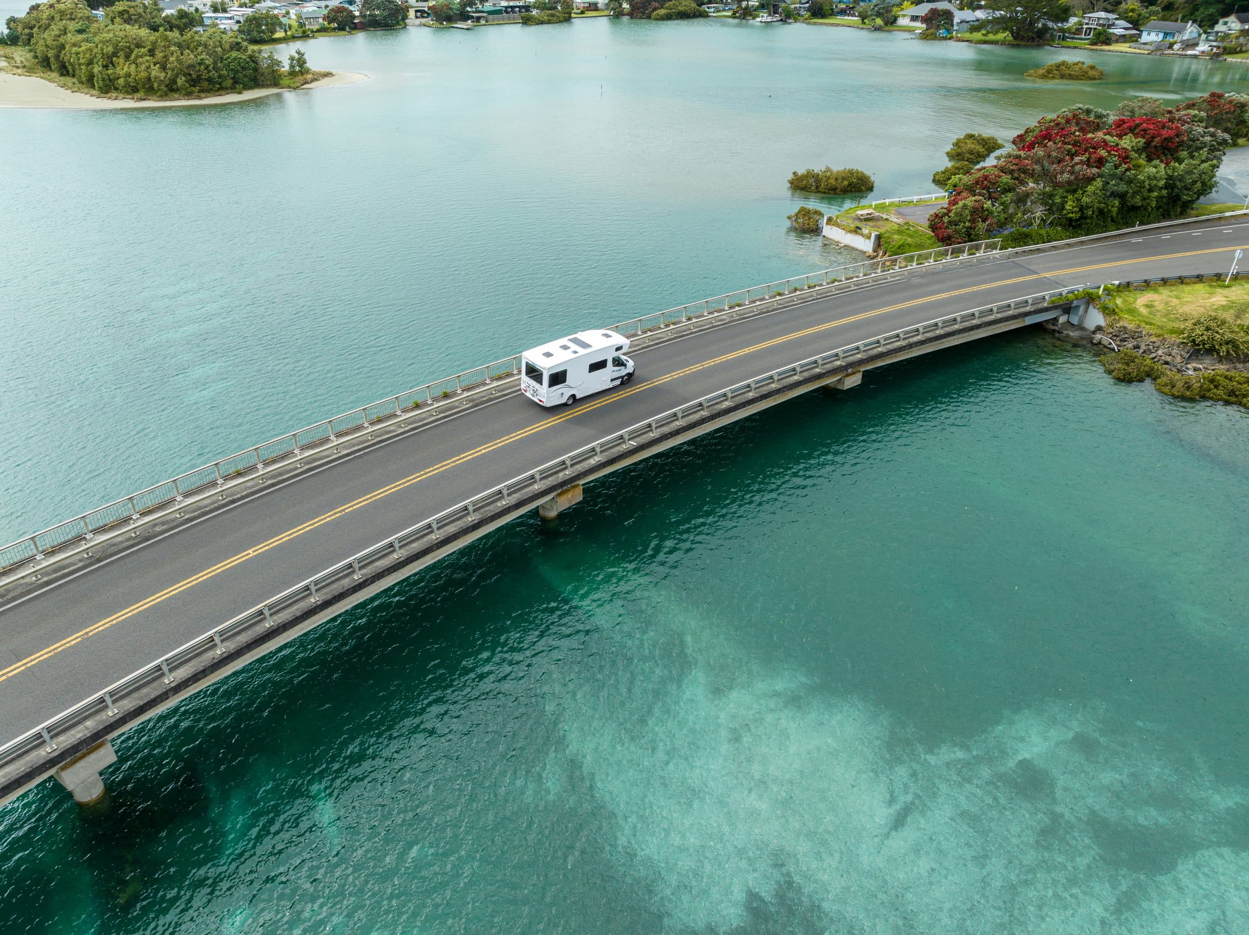 Camper op brug boven helder water Nieuw-Zeeland