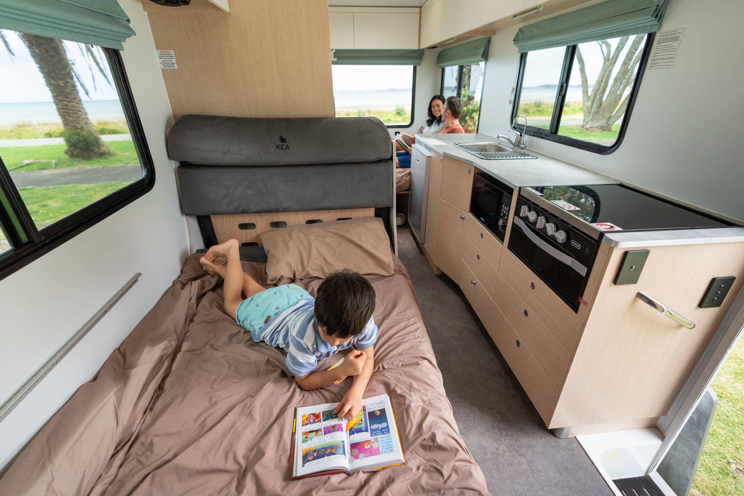 Kind leest stripboek in camper Nieuw-Zeeland