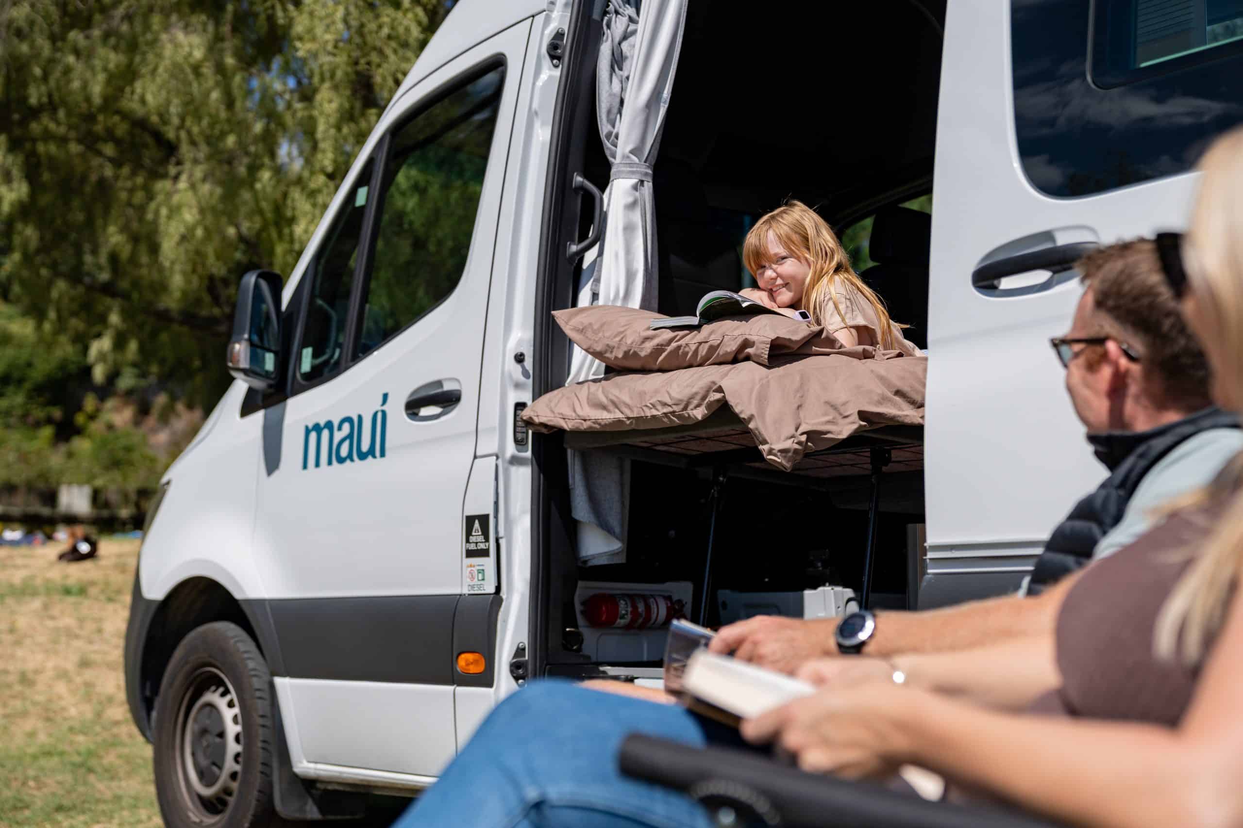 Meisje leest boek in camperdeur Nieuw-Zeeland