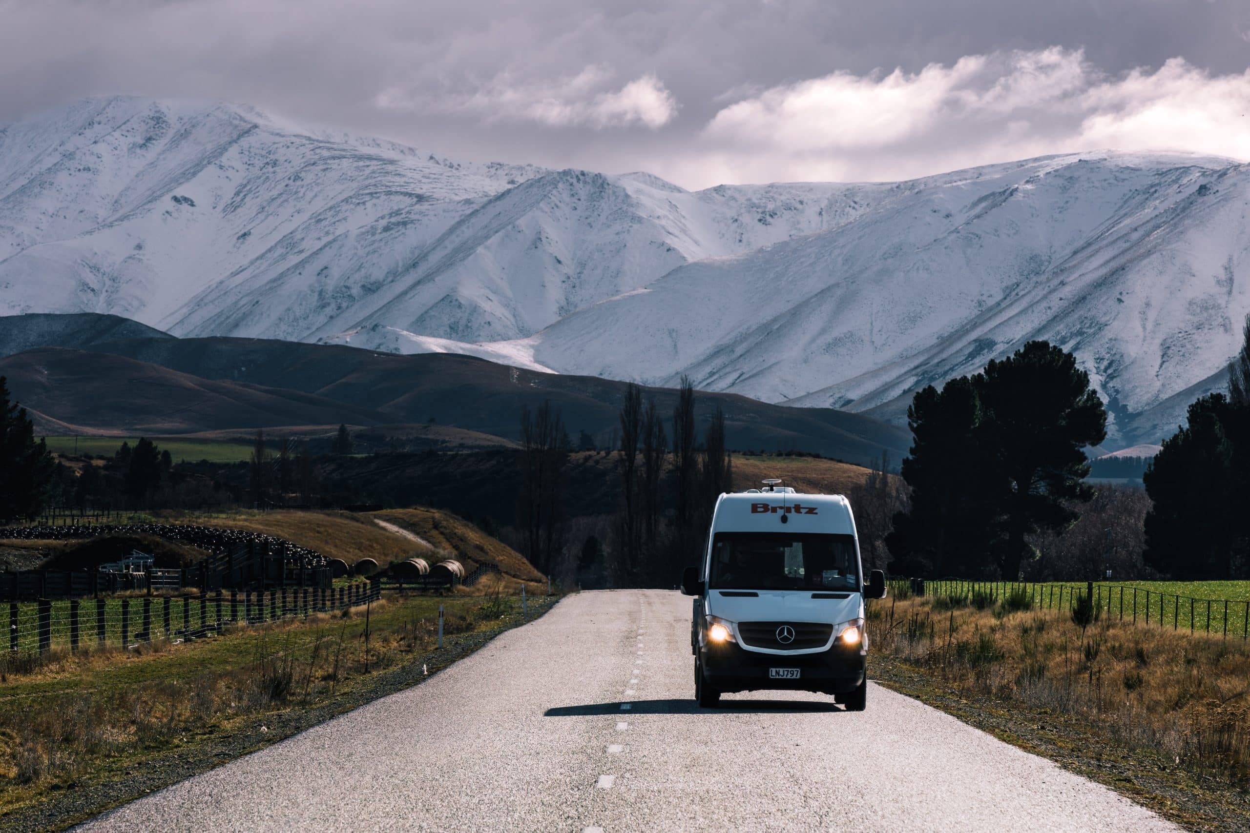 Camper op weg met besneeuwde bergen Nieuw-Zeeland