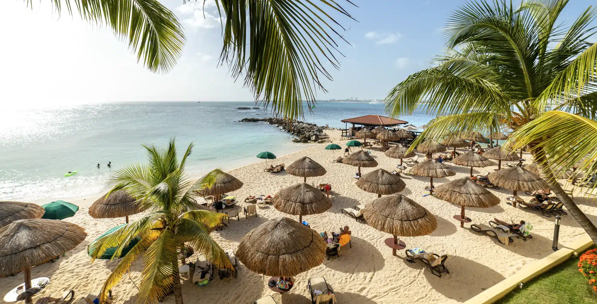 Strand met palmbomen en rieten parasols in Sint Maarten