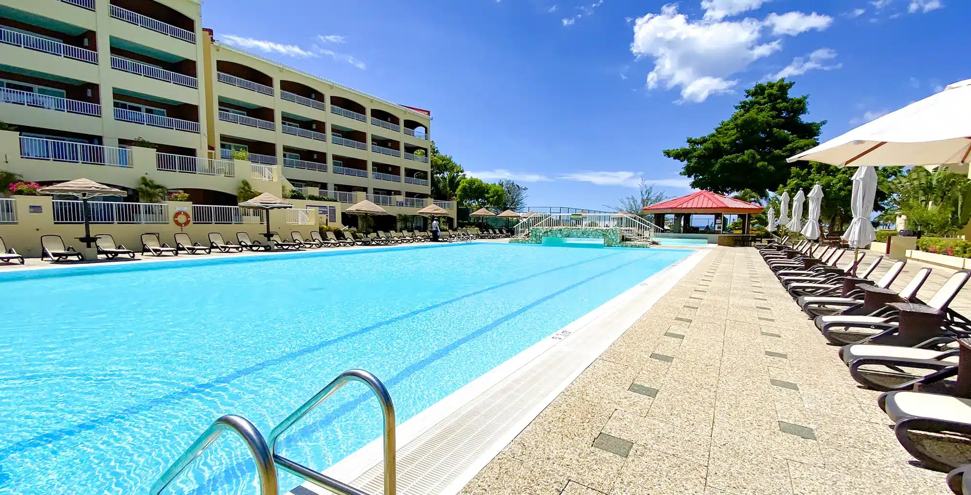 Groot zwembad met ligstoelen bij resort in Sint Maarten