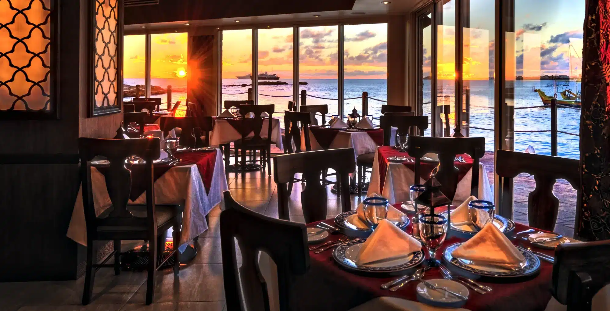 Restaurant met tafels en zeezicht bij zonsondergang in Sint Maarten